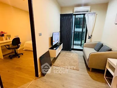 Modern living room with cozy sofa, TV, and balcony access in stylish apartment