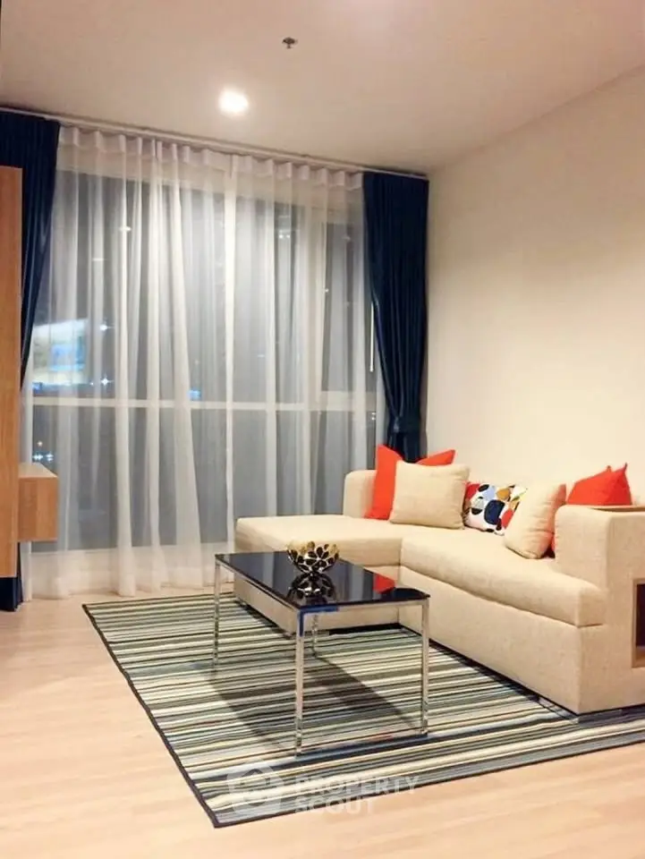 Modern living room with stylish decor, large window, and cozy seating area in a contemporary apartment.