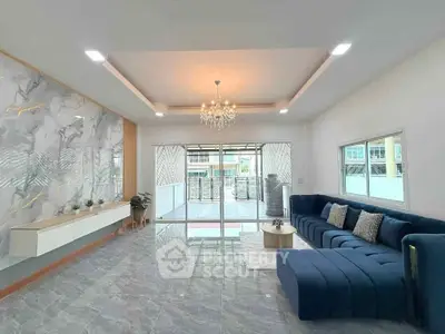 Spacious modern living room with elegant chandelier and stylish blue sectional sofa