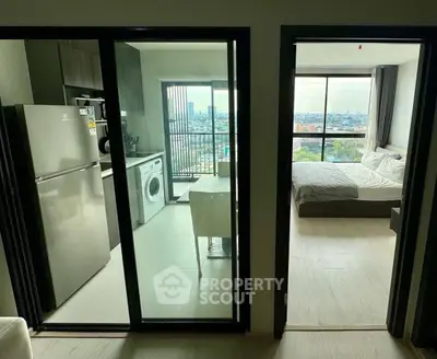 Modern apartment with kitchen, washing machine, and bedroom with city view balcony.
