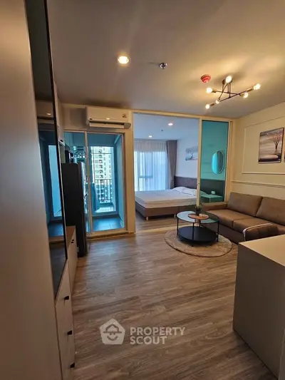 Modern open-plan living room with cozy bedroom and stylish decor in a contemporary apartment.