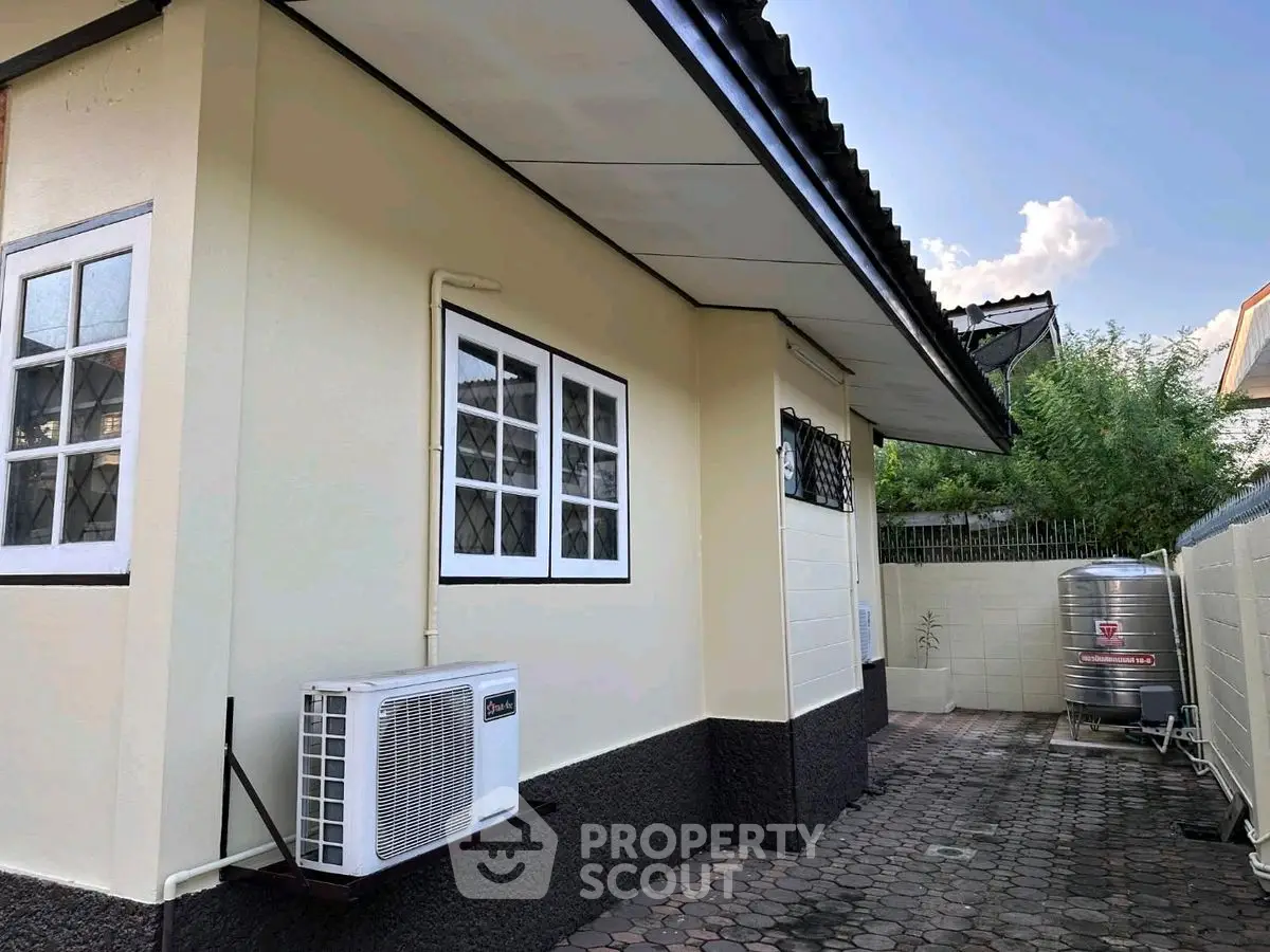 Charming single-story home exterior with air conditioning and paved pathway