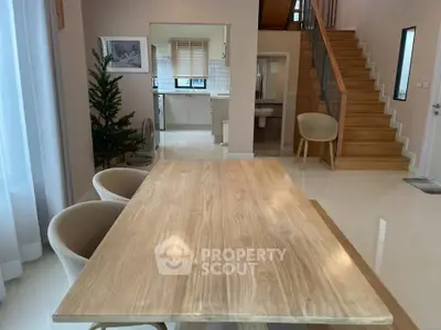 Spacious modern dining area with wooden table and open kitchen view