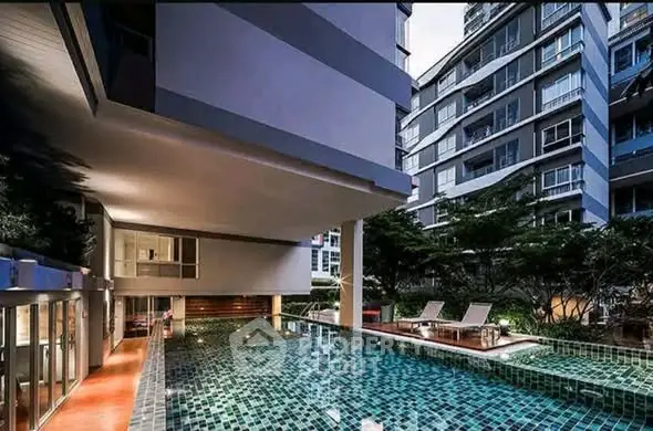 Luxurious condominium with modern pool and stylish architecture, perfect for urban living.