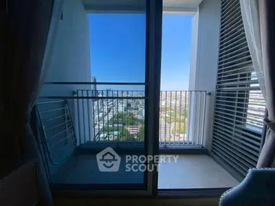 Modern balcony with city view and sliding glass doors in urban apartment.