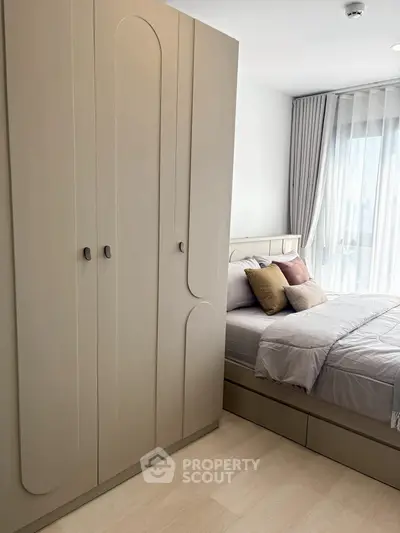 Modern bedroom with sleek wardrobe and cozy bed setup