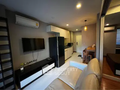 Modern living room with open kitchen, sleek furniture, and ambient lighting in a stylish apartment.