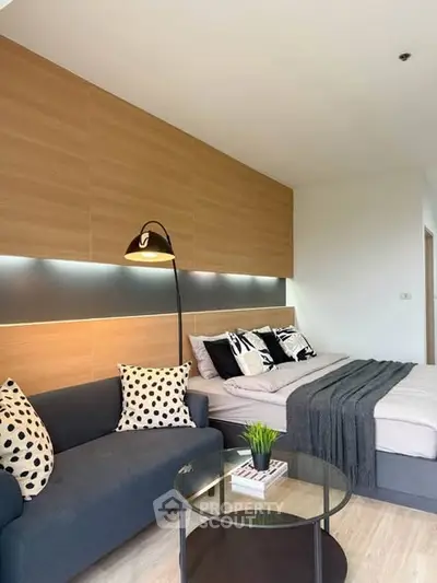 Modern bedroom with stylish decor and cozy seating area in a contemporary apartment.