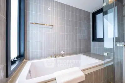 Luxurious modern bathroom with elegant bathtub and stylish tile design.