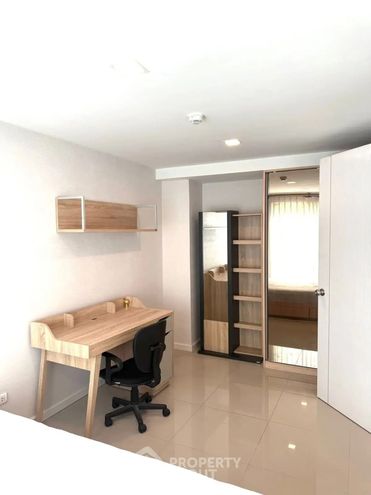 Modern study room with sleek desk and chair, ample storage, and bright lighting.