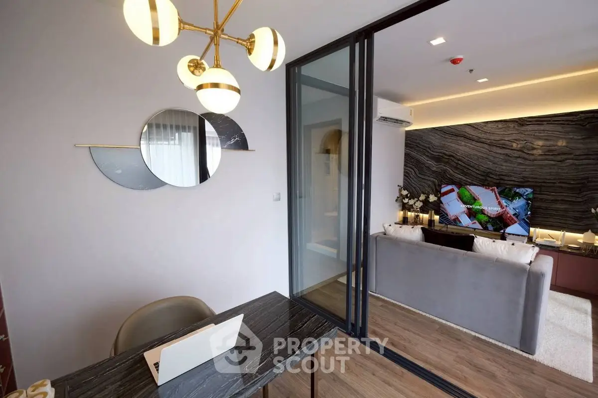 Modern living room with stylish decor and open layout, featuring a sleek black marble table and elegant lighting.