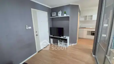 Modern living room with sleek TV setup and open kitchen layout
