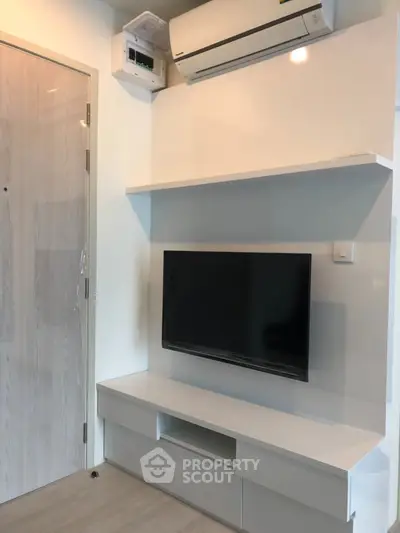 Modern living room with wall-mounted TV and air conditioning unit