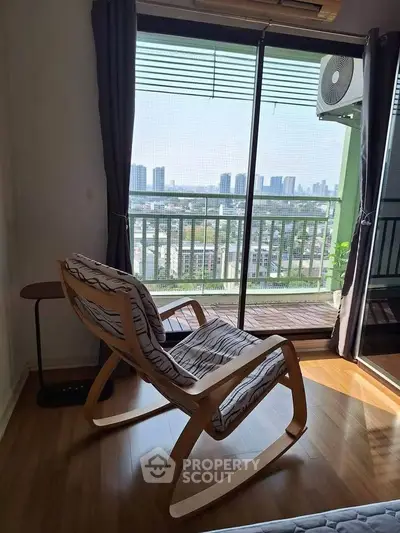 Charming living room with rocking chair and balcony view of city skyline.