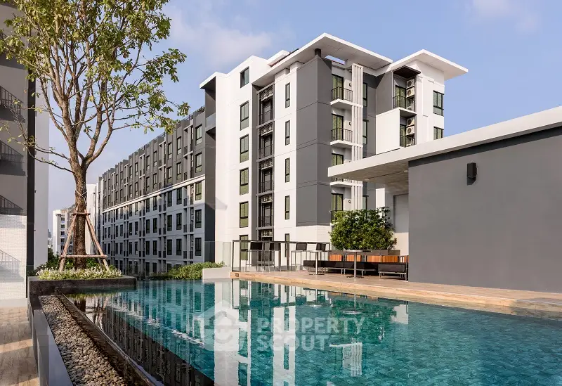 Modern apartment complex with pool and lush greenery, perfect for urban living.