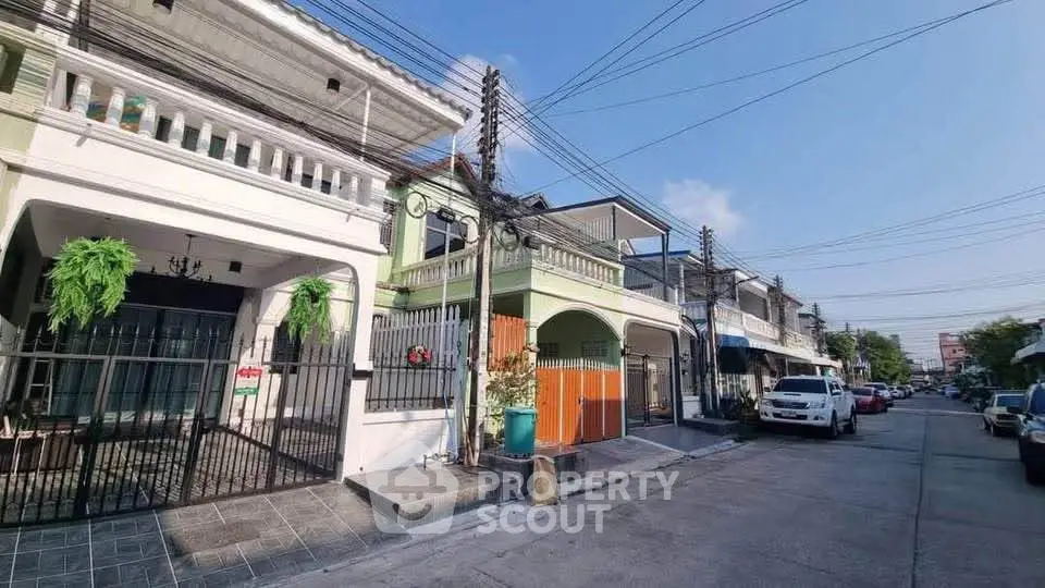 Charming residential street with modern townhouses and ample parking space.