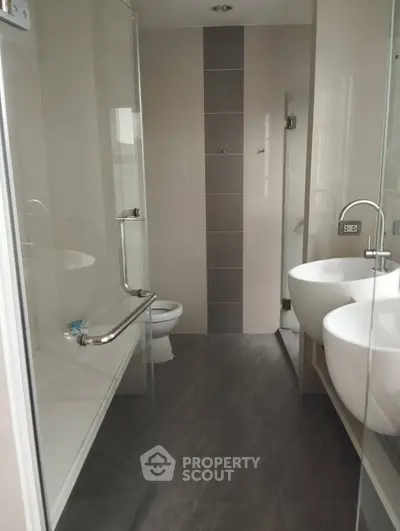Modern bathroom with dual sinks and glass shower enclosure
