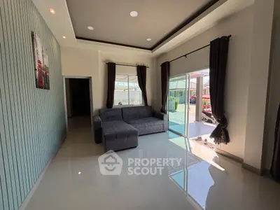 Spacious living room with modern decor and large sliding glass doors leading to outdoor area.