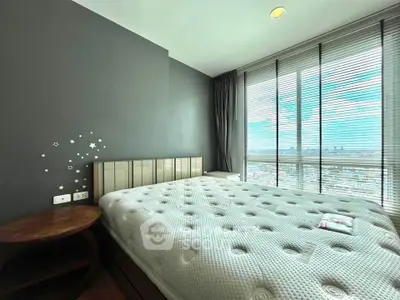 Spacious bedroom with large windows offering stunning city views, modern decor, and cozy ambiance.