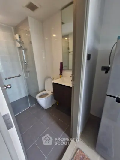 Modern bathroom with glass shower and sleek fixtures in contemporary apartment.