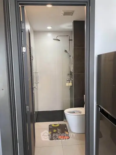 Modern bathroom with sleek shower and toilet in contemporary apartment.