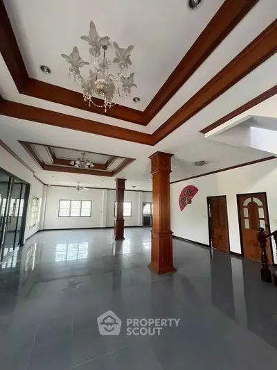 Spacious open-plan living area with elegant ceiling design and natural light.