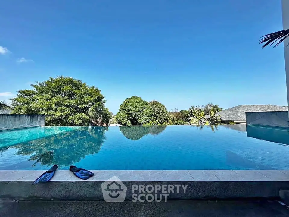 Luxurious infinity pool with stunning views and lush greenery, perfect for relaxation and leisure.