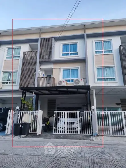 Modern townhouse exterior with gated parking and balcony