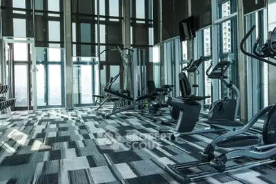 Luxurious high-rise gym with modern equipment and panoramic city views.