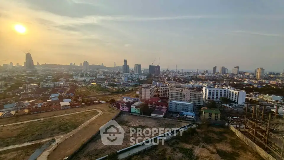 Stunning cityscape view from a high-rise building at sunset, showcasing urban skyline and expansive horizon.