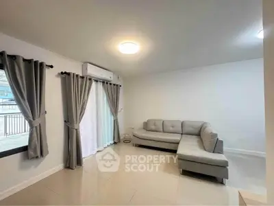 Spacious living room with modern gray sofa and large windows for natural light.
