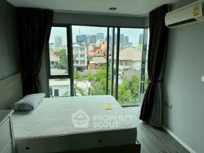 Modern bedroom with city view, large windows, and air conditioning in urban apartment.