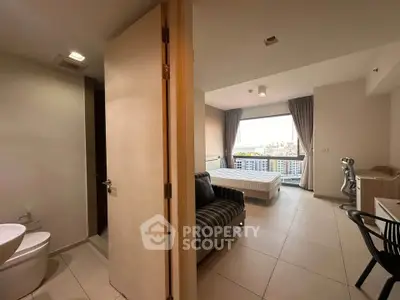 Modern apartment interior with bedroom and bathroom, featuring city view and stylish furnishings.