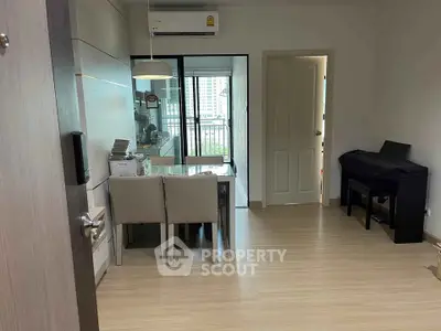 Modern dining area with sleek furniture and balcony view in a stylish apartment.