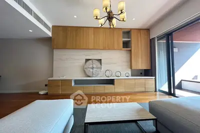 Spacious modern living room with elegant wooden cabinetry and stylish chandelier