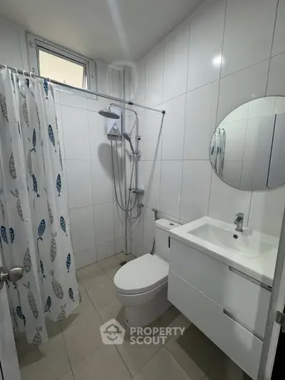 Modern bathroom with sleek fixtures and stylish shower curtain in a bright, tiled space.