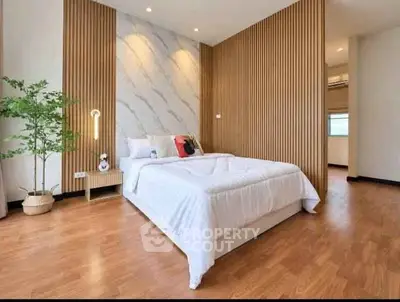 Modern bedroom with stylish wood paneling and cozy decor
