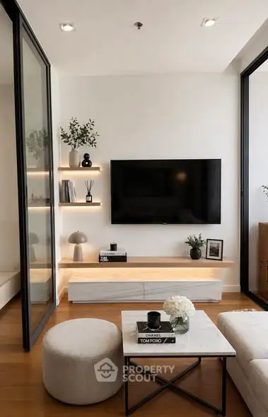 Modern living room with sleek design, featuring a wall-mounted TV, stylish shelves, and elegant decor.