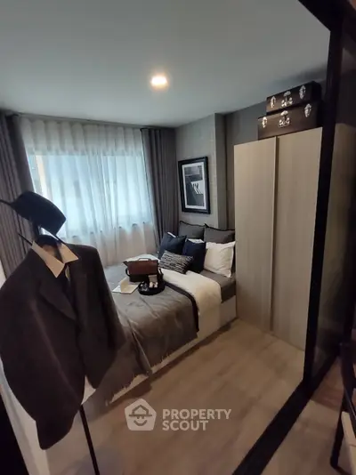 Cozy bedroom with modern decor and ample natural light, featuring stylish wardrobe and elegant furnishings.