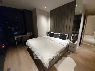 Luxurious modern bedroom with city view, featuring elegant decor and ambient lighting.