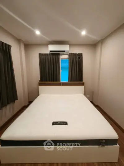 Cozy bedroom with modern design, featuring a comfortable bed and air conditioning for ultimate relaxation.