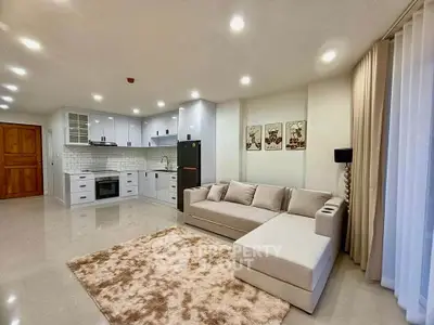 Spacious modern living room with open kitchen layout and cozy sofa