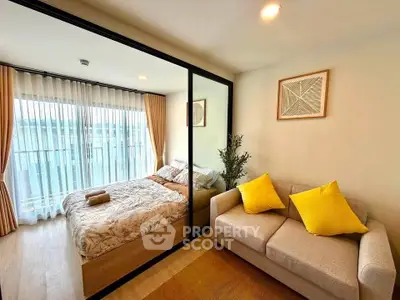 Modern studio apartment with cozy bedroom and stylish living area, featuring large windows and natural light.