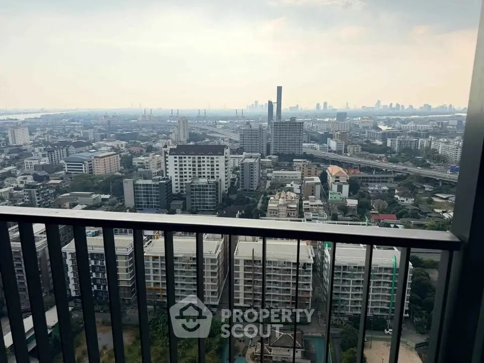 Stunning cityscape view from a high-rise balcony overlooking urban skyline.