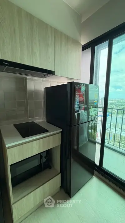 Modern kitchen with sleek appliances and stunning city view from balcony.