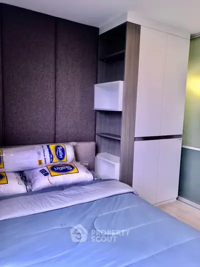 Modern bedroom with stylish built-in wardrobe and cozy bedding