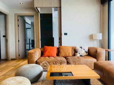 Modern living room with stylish leather sofa and vibrant cushions, featuring wooden flooring and natural light.