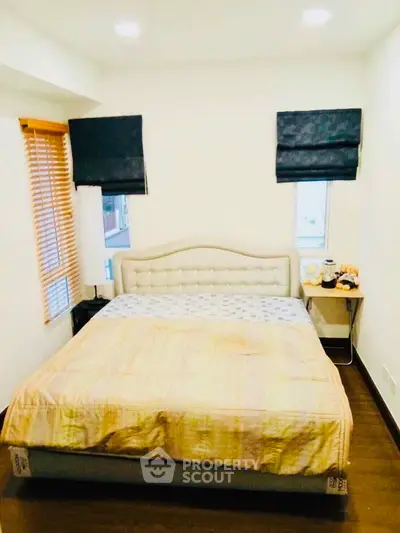 Cozy bedroom with modern decor and ample natural light, featuring a comfortable bed and stylish window treatments.