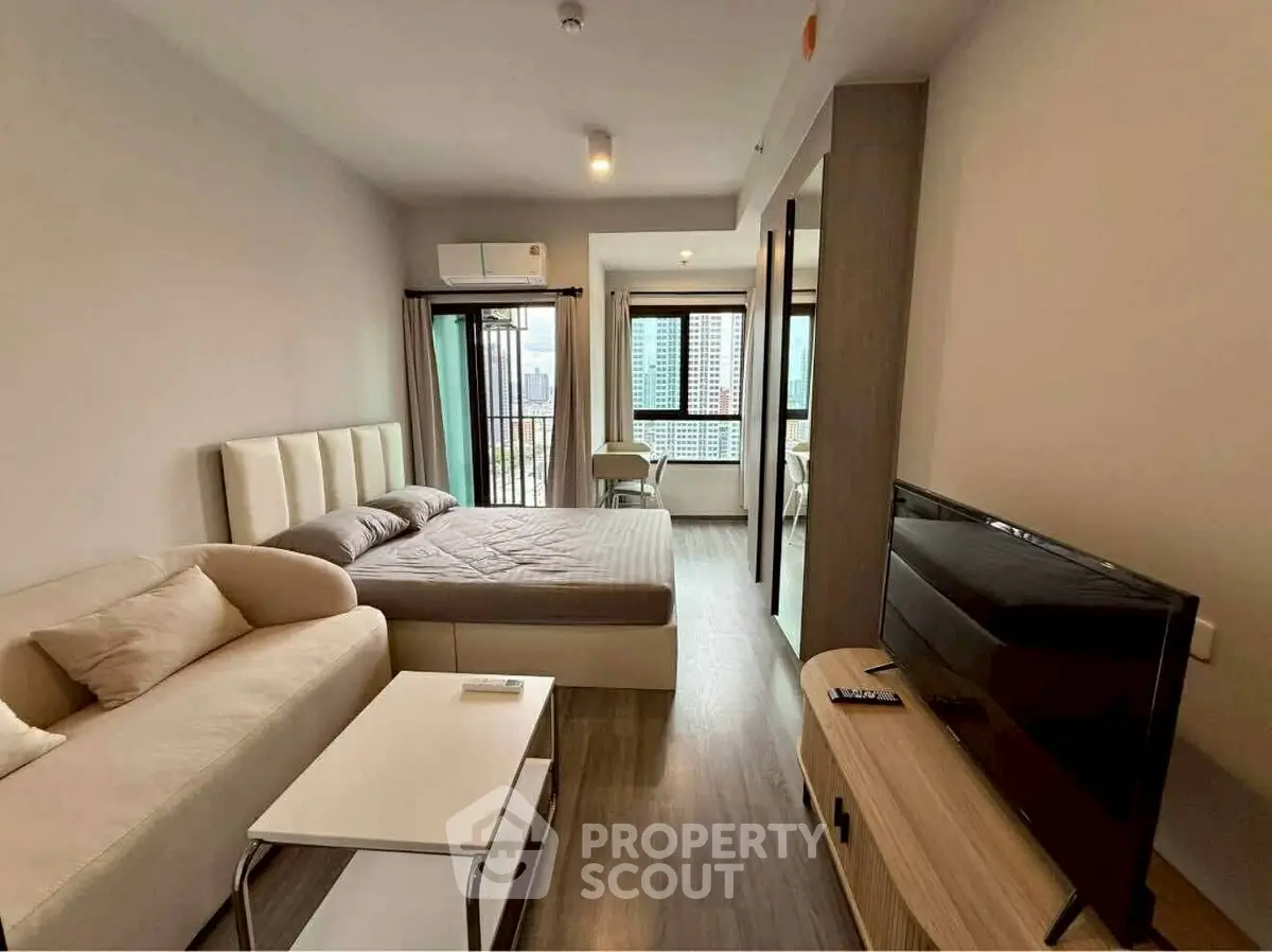 Modern studio apartment with cozy living area and city view
