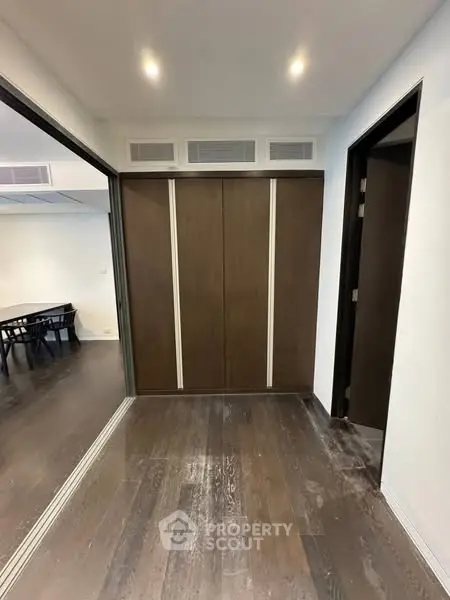 Spacious hallway with dark wood flooring and modern sliding doors in a contemporary home.